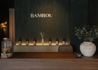 L'entrée accueillante de Bambou Massage à Uccle, Bruxelles, BE, avec des huiles et une plante décorative.