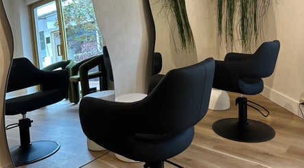 Modern salon setup at Salon Samar, Newport, New South Wales, AU featuring stylish black chairs and mirrors.