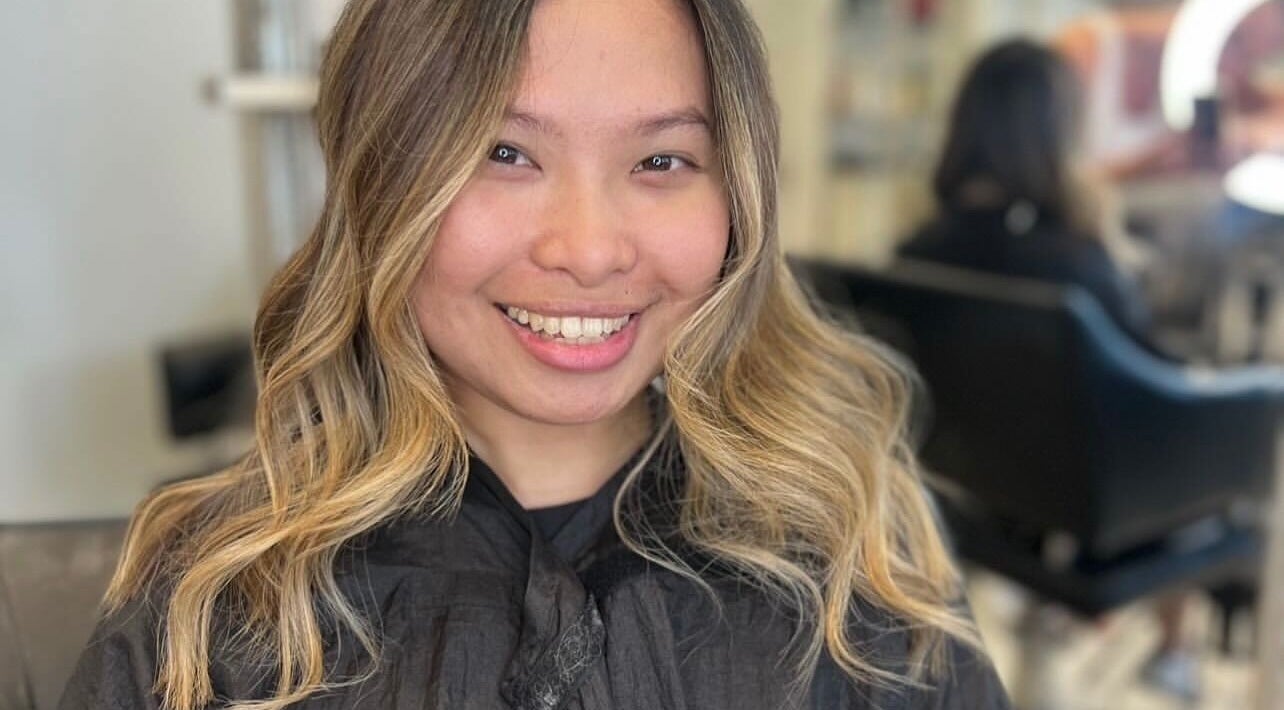 Woman with styled blonde waves at Styled by Court, Sutton, England, GB. Hair salon ambiance enhances her look.