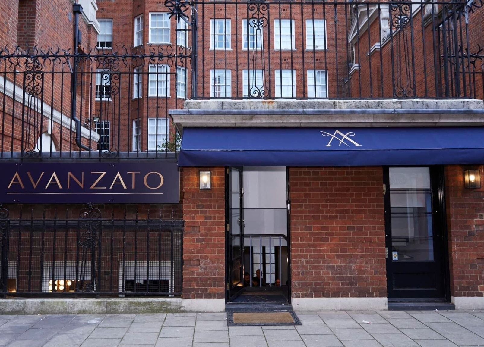 Entrance of Avanzato Grooming Lounge, a stylish venue in London, England, GB, with classic brick facade.