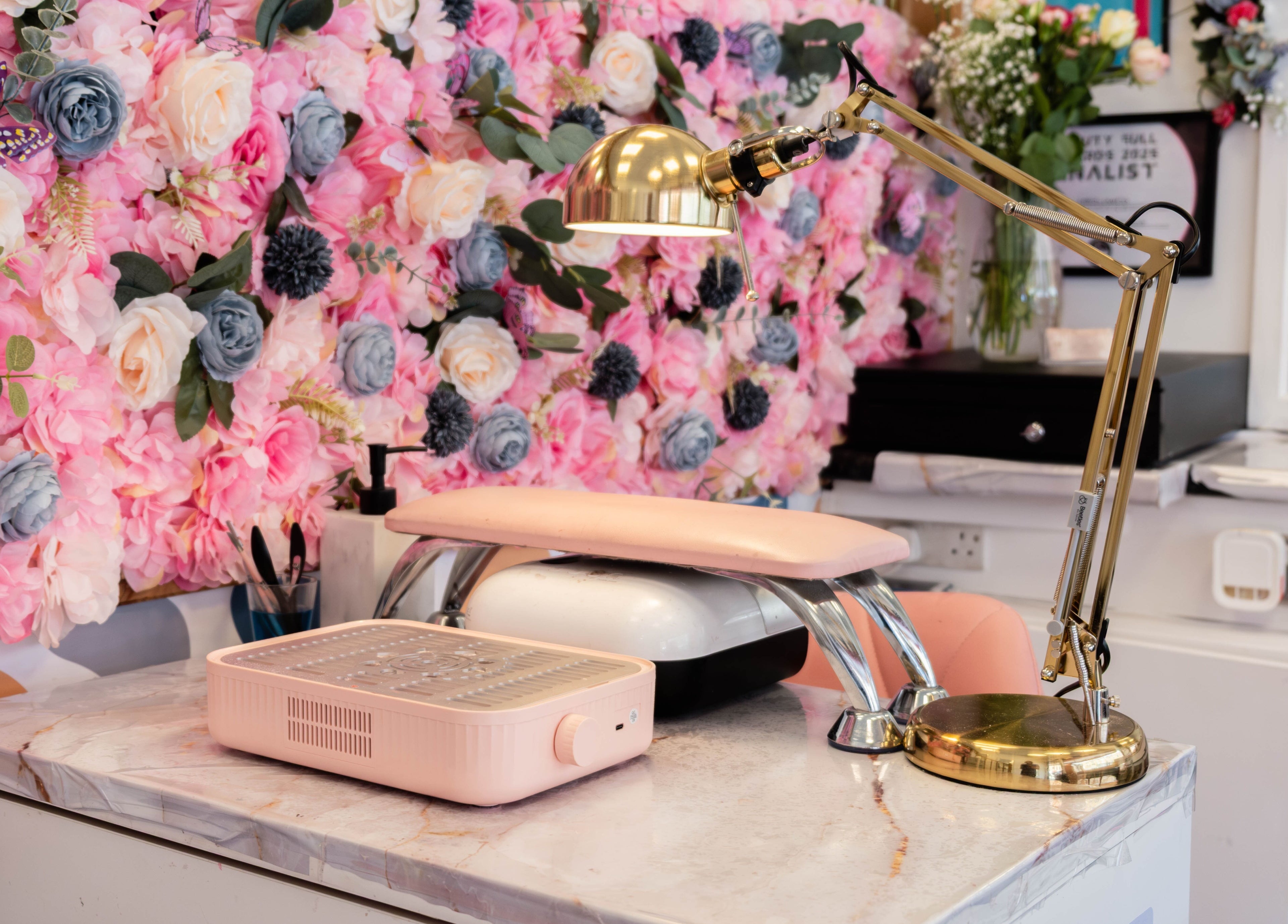 Cozy nail station with floral backdrop at HR Glow Co in London, England, GB, perfect for beauty treatments.