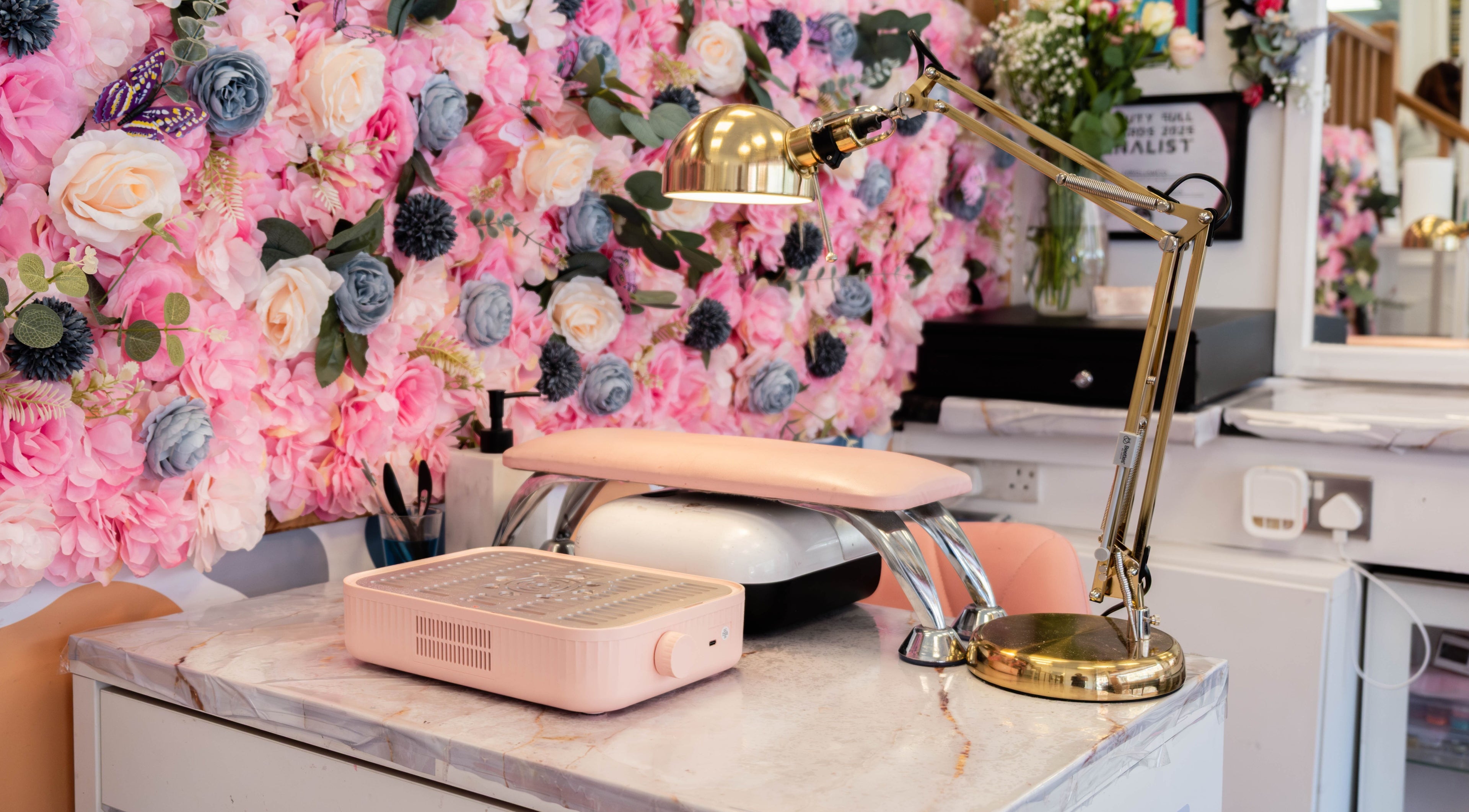 Cozy nail station with floral backdrop at HR Glow Co in London, England, GB, perfect for beauty treatments.