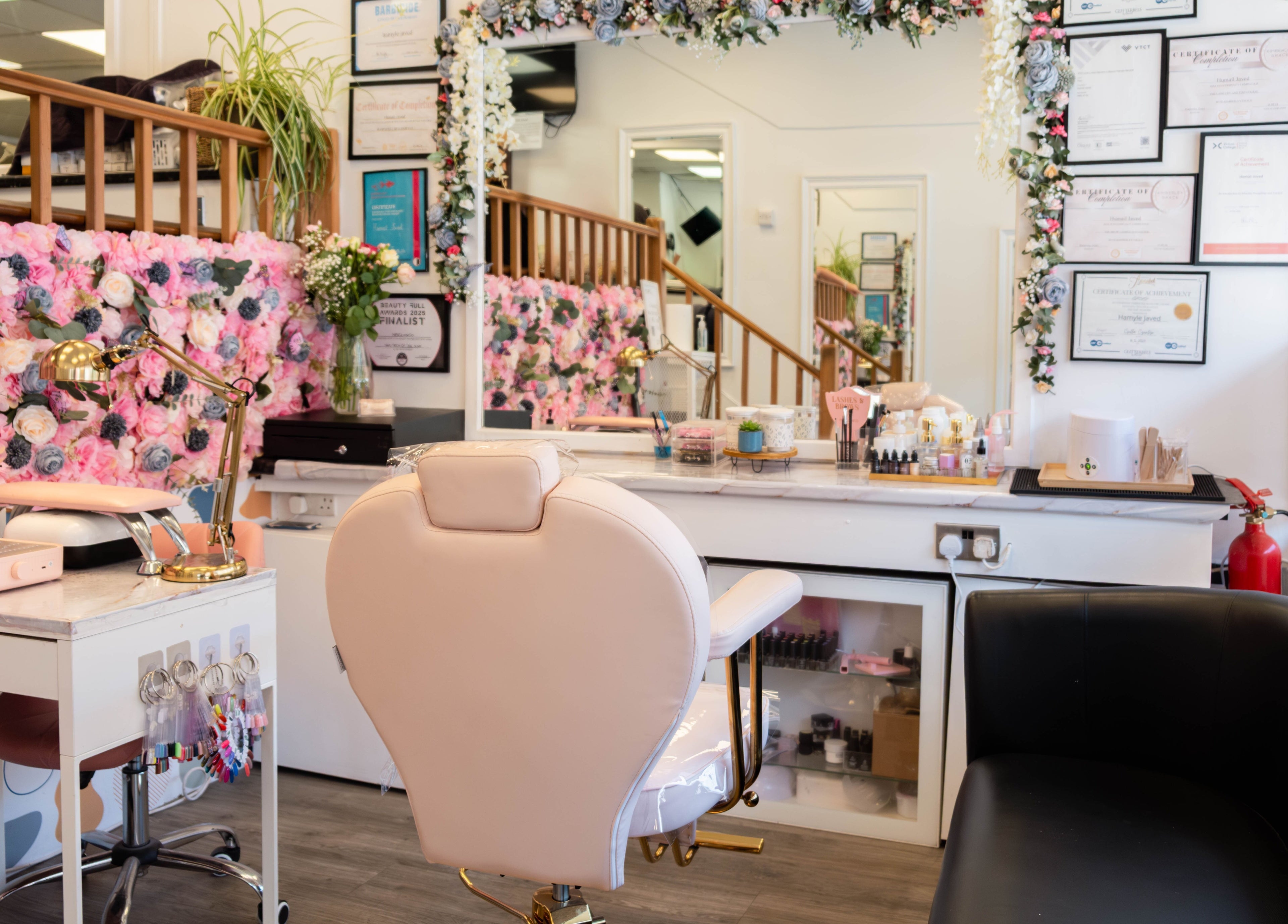 Inside HR Glow Co, London, England, GB. Elegant beauty salon with floral decor and modern styling chair.