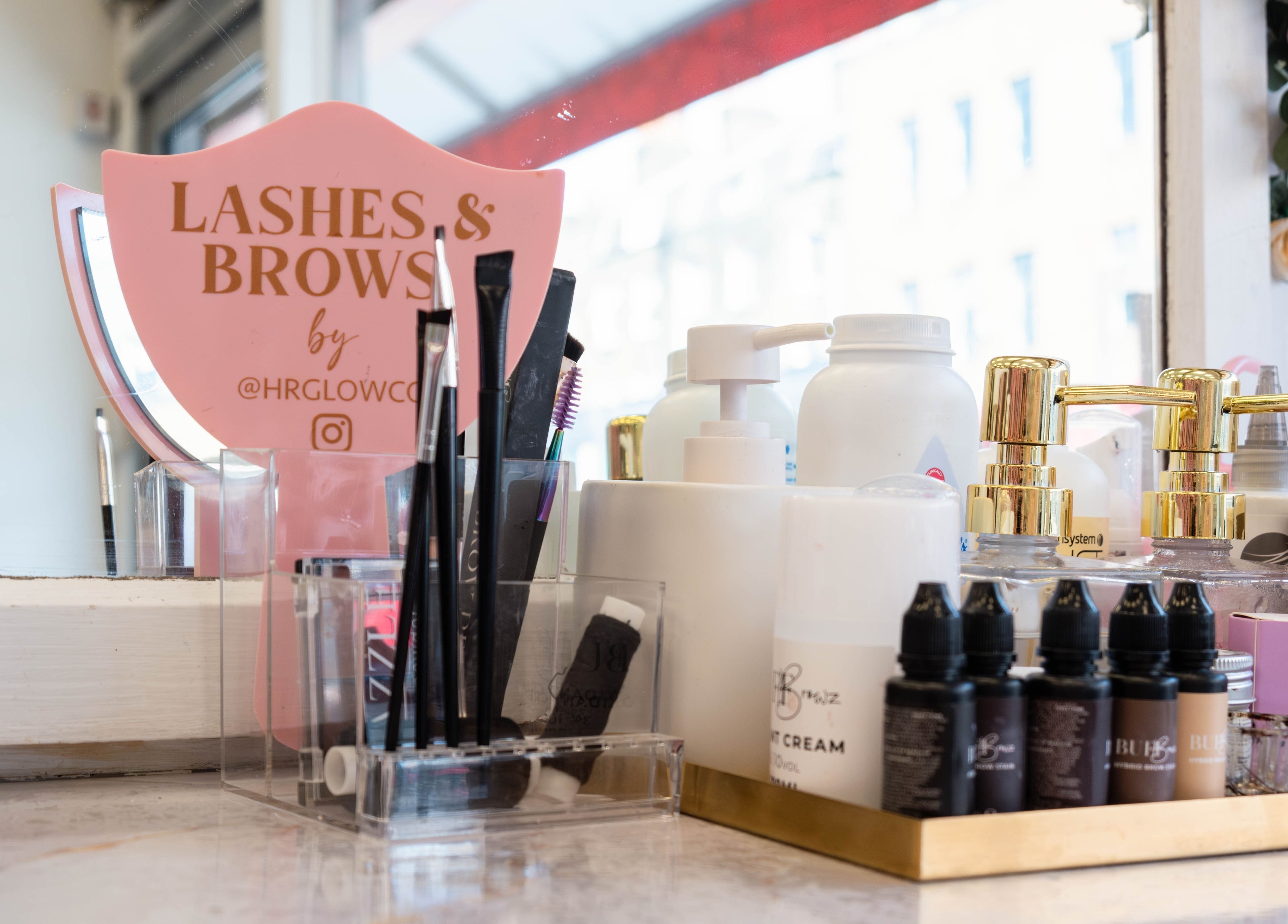 HR Glow Co beauty products display on a vanity in London, England, GB with pink and gold accents.