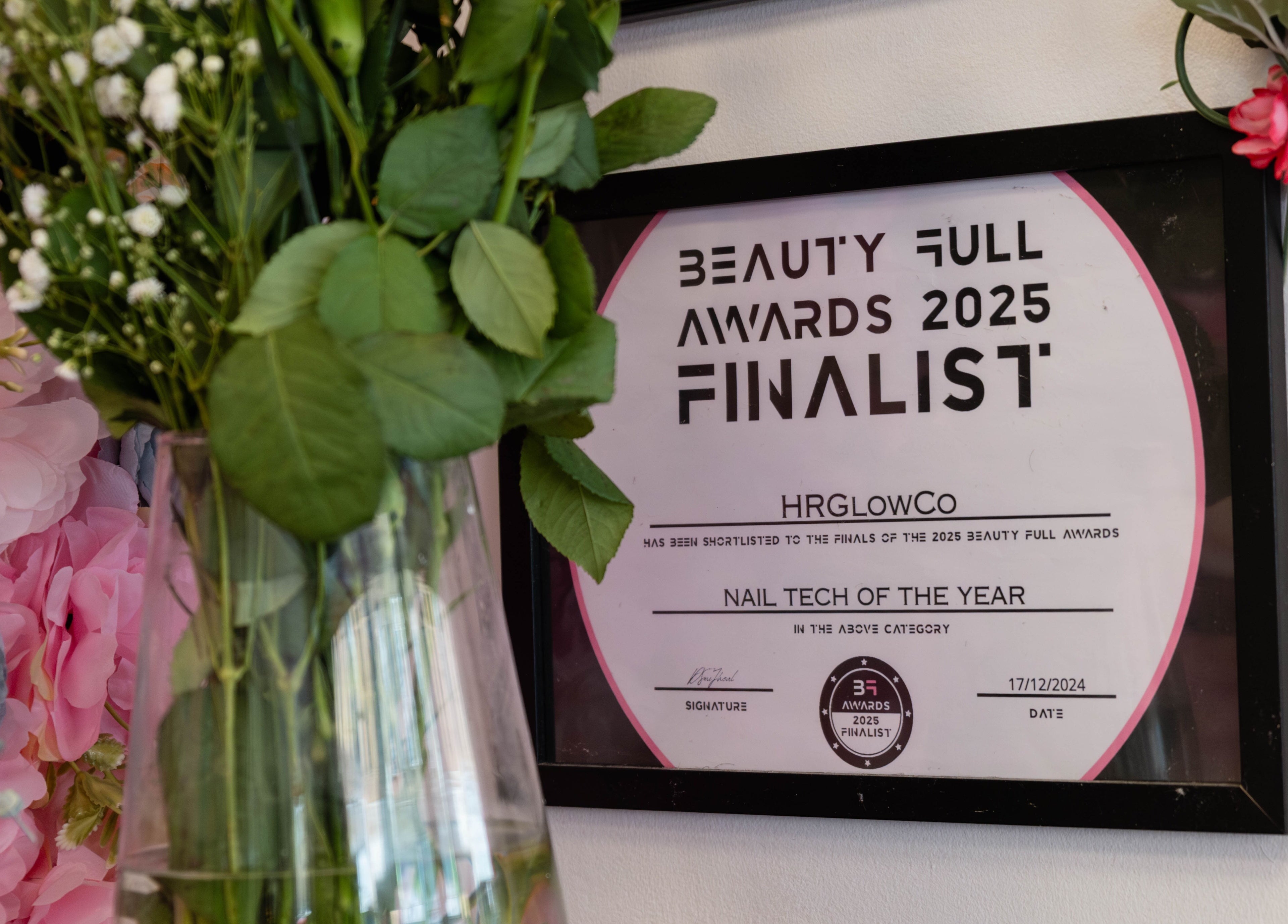 HR Glow Co's Beauty Full Awards 2025 finalist plaque displayed in London, England, GB adorned with flowers.