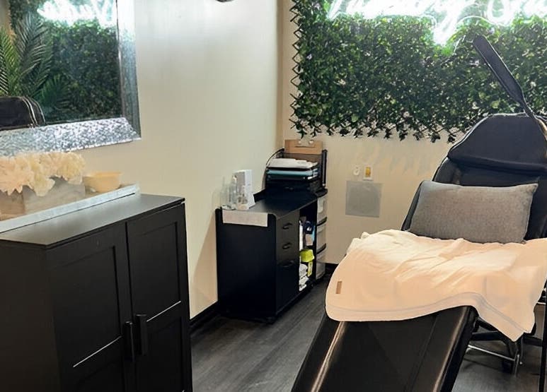 Tuscany Studio treatment room with modern decor in Hamilton, Ontario, CA featuring a relaxing chair and greenery.