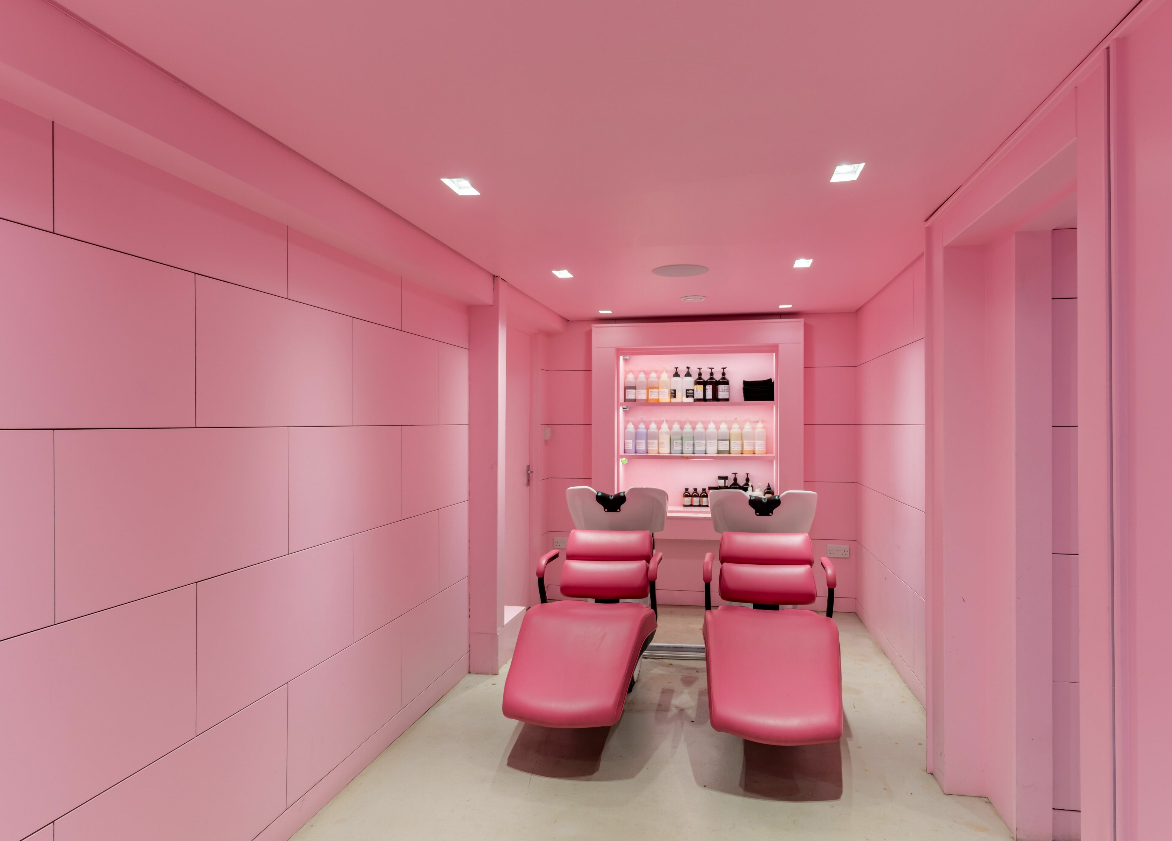 Vibrant pink salon chairs at Crab Salad Peckham, London, GB offering a chic and modern beauty experience.