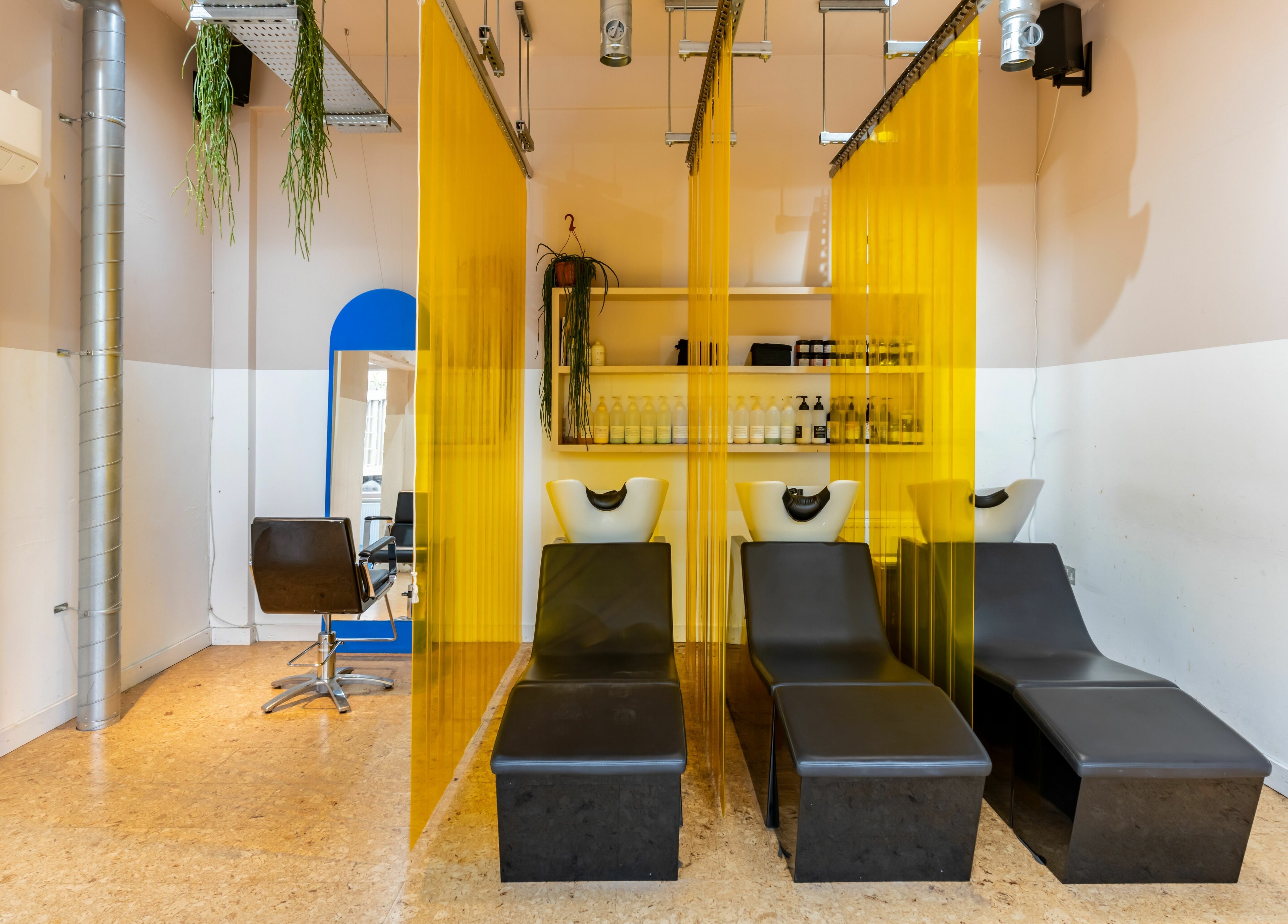 Modern salon interior at Crab Salad Peckham, London, GB with stylish chairs and vibrant yellow dividers.