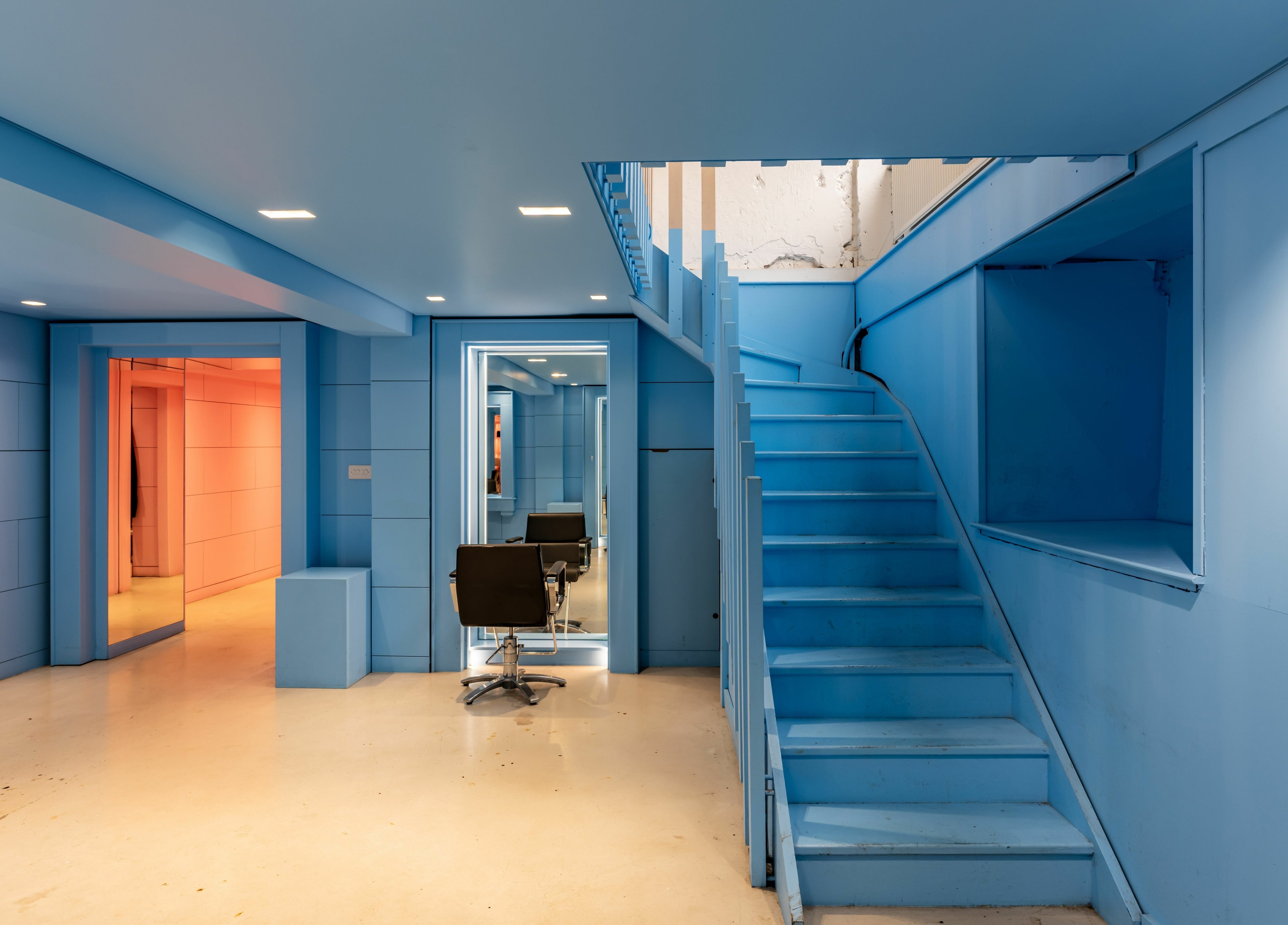Modern interior of Crab Salad Peckham in blue tones with a stylish staircase in London, GB.
