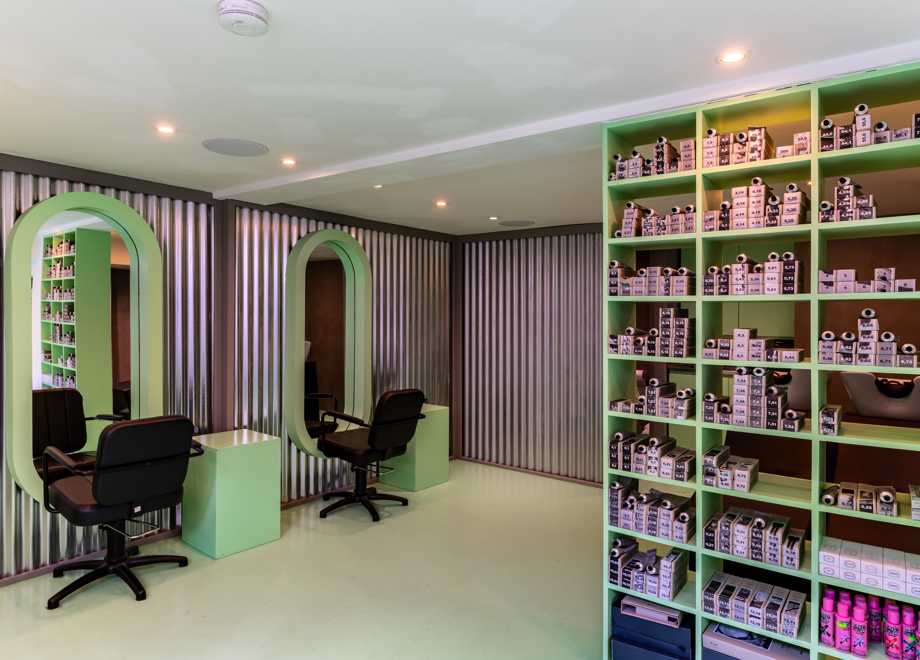 Modern salon interior at Crab Salad Highbury in London, GB with sleek chairs and vibrant shelving.
