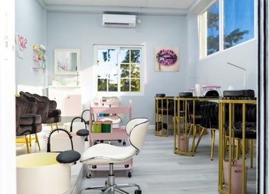 Elegant interior of Belle Lounge Spa in Saint George, Saint George, GD with plush seating and nail stations.