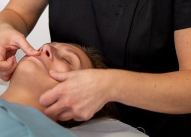 Therapist performing a facial massage at Healing Touch Therapies (Millbrook), Southampton, England, GB.