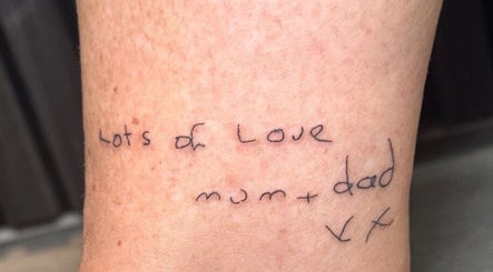 Handwritten text tattoo 'Lots of Love, mum + dad' at Finelines by Fern Tattoo, Wickford, England, GB.