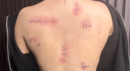 Back with minimalist tattoos at Finelines by Fern Tattoo, Wickford, England, GB showcasing delicate designs.