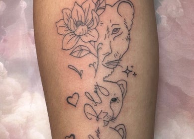 Elegant lion outline tattoo with floral elements at Finelines by Fern Tattoo, Wickford, England, GB.