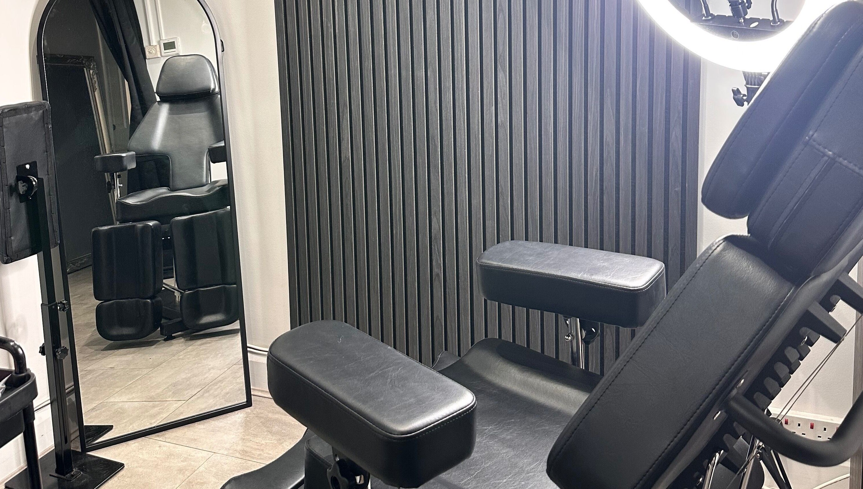 Modern tattoo chair at Finelines by Fern Tattoo, Wickford, England, GB, showcasing sleek black design.