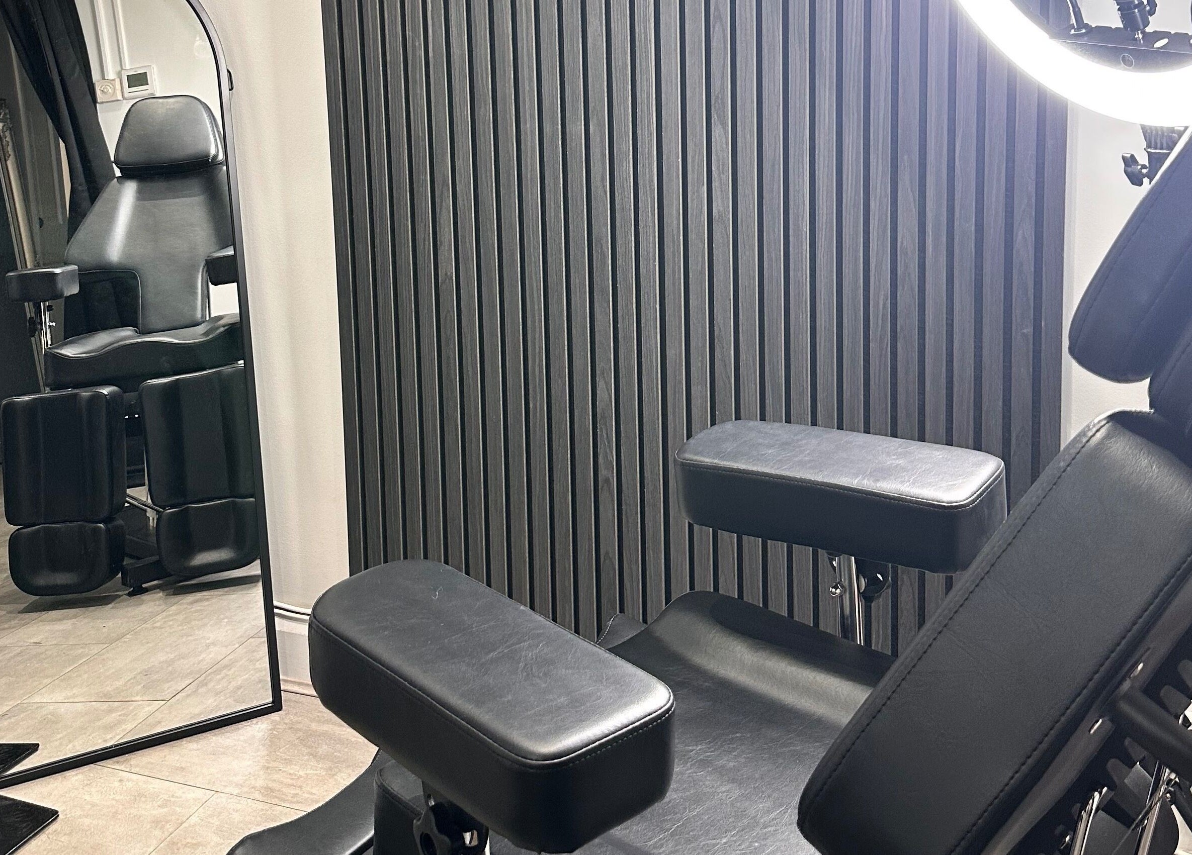 Modern tattoo chair at Finelines by Fern Tattoo, Wickford, England, GB, showcasing sleek black design.