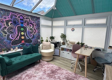 Peaceful Inner Divine Beauty studio in Manchester, England, GB with vibrant chakra tapestry and cozy seating.