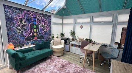 Peaceful Inner Divine Beauty studio in Manchester, England, GB with vibrant chakra tapestry and cozy seating.