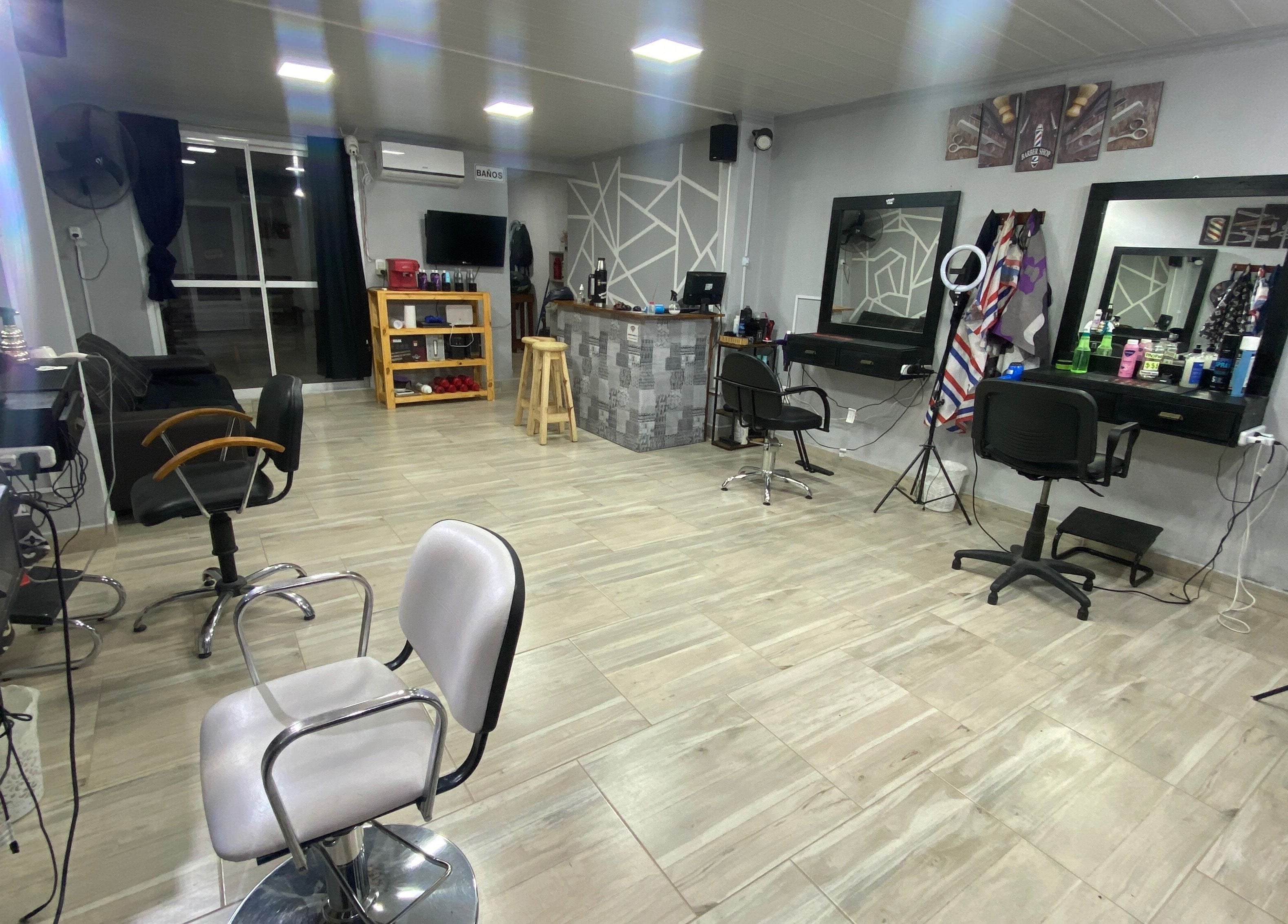 Interior moderno de Barber Club en Concepción Del Uruguay, Entre Ríos, AR, con sillas y espejos elegantes.