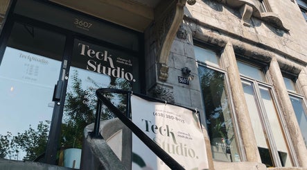 Entrée principale de Teck Studio à Montréal, Québec, CA, avec une façade en pierre et des détails architecturaux.