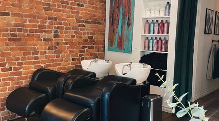Stations de lavage modernes au Teck Studio, Montréal, Québec, CA, avec un mur de briques et des produits de soins.