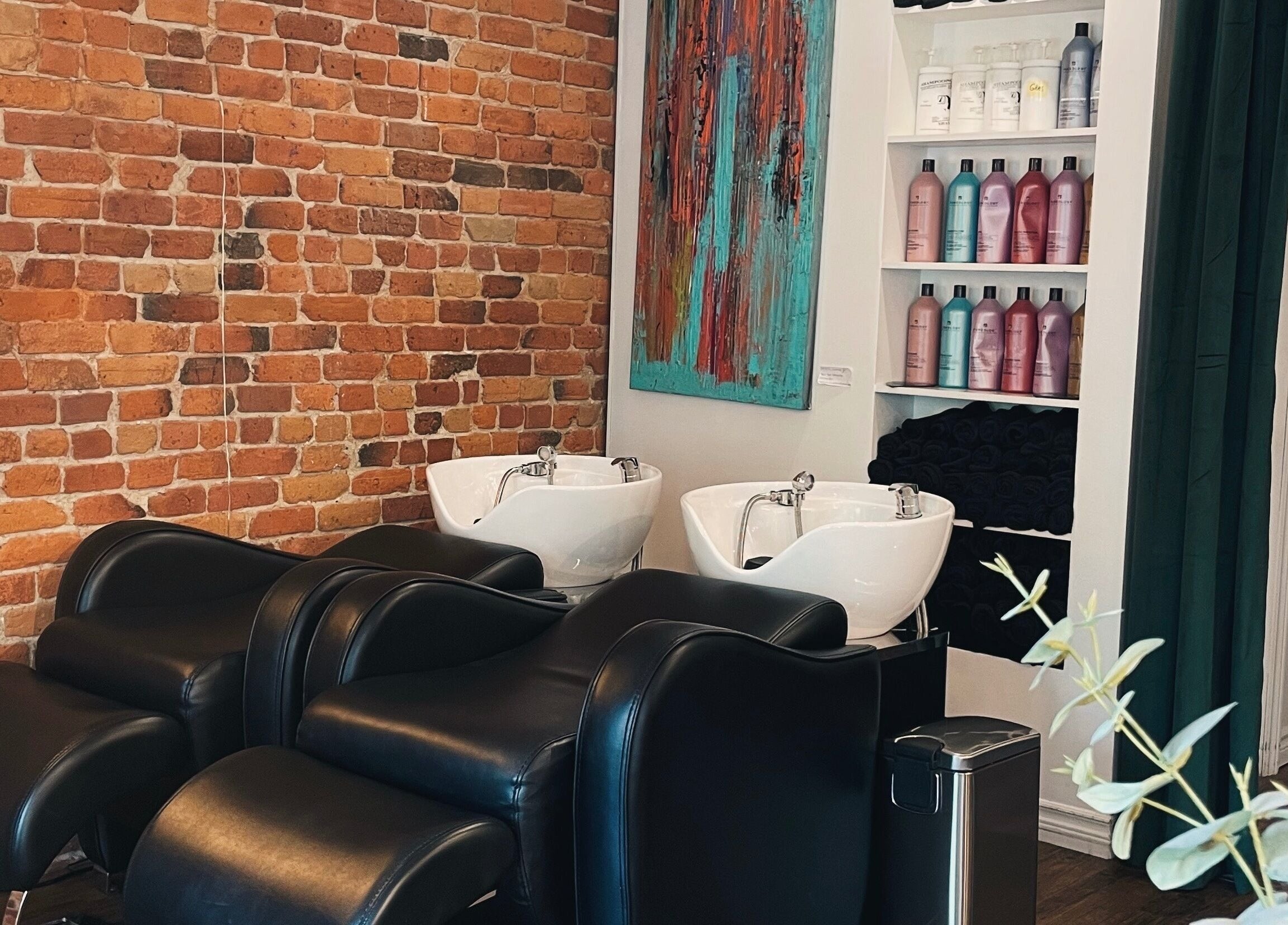 Bacs de lavage modernes chez Teck Studio, Montréal, Québec, CA, devant un mur de briques élégant.