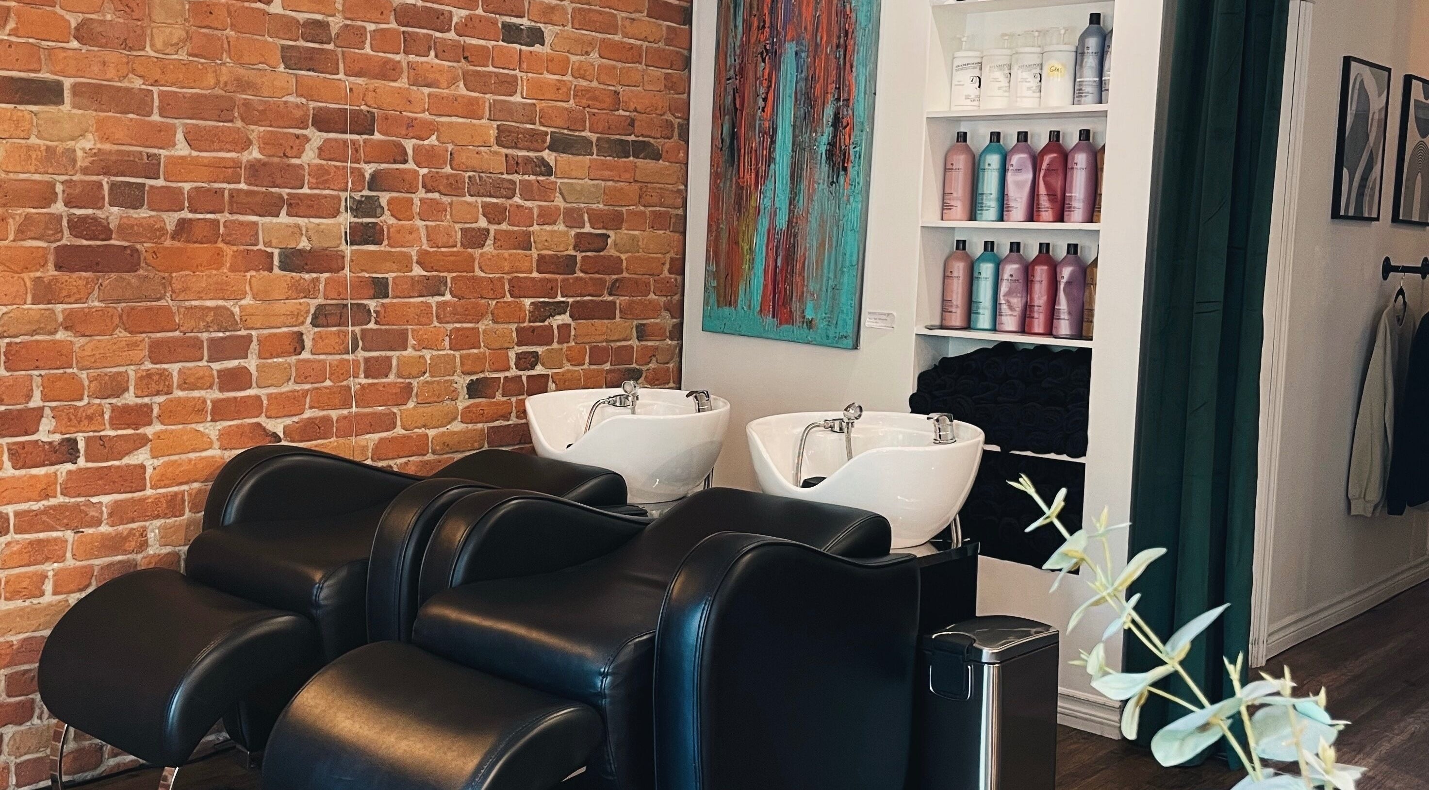 Bacs de lavage modernes chez Teck Studio, Montréal, Québec, CA, devant un mur de briques élégant.