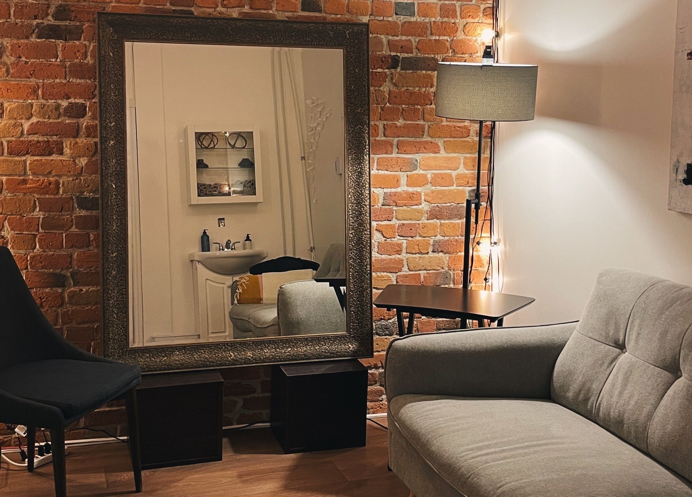 Intérieur chaleureux du Teck Studio à Montréal, Québec, CA avec canapé élégant et mur en briques.