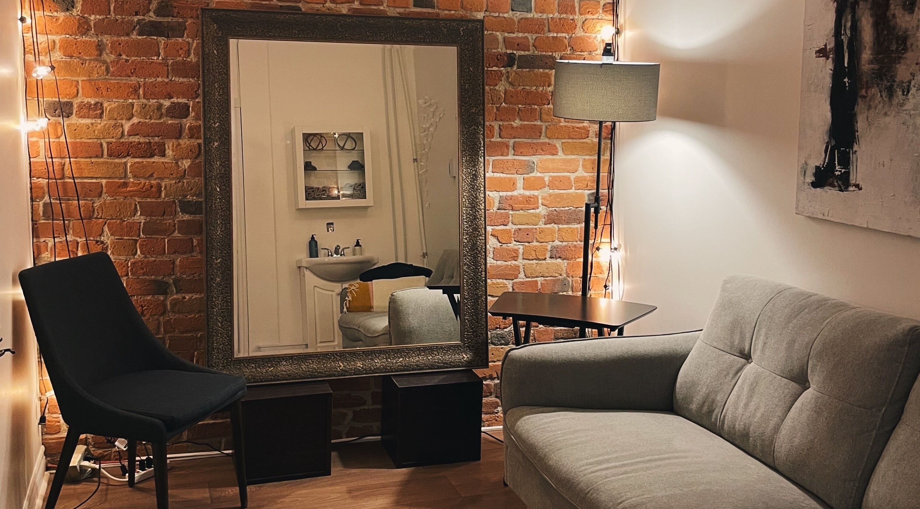 Intérieur chaleureux du Teck Studio à Montréal, Québec, CA avec canapé élégant et mur en briques.