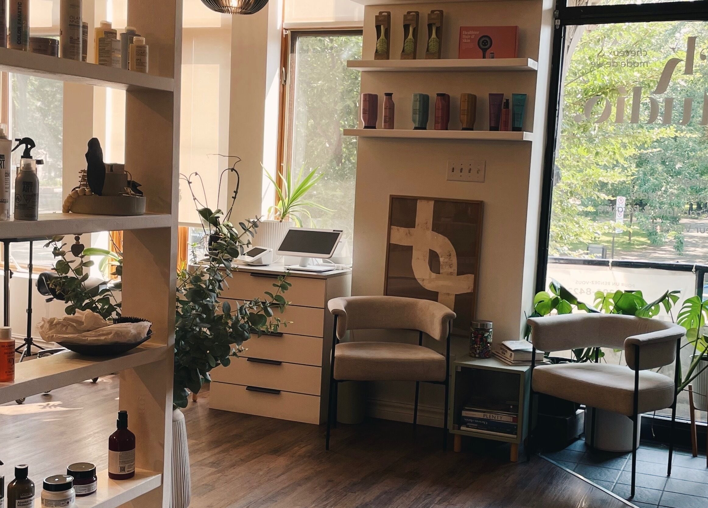 Intérieur de Teck Studio à Montréal, Québec, CA, avec étagères de produits beauté et fauteuils modernes.