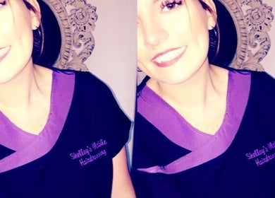 Smiling stylist at Hair By Shelley, Braintree, England, GB in branded uniform.