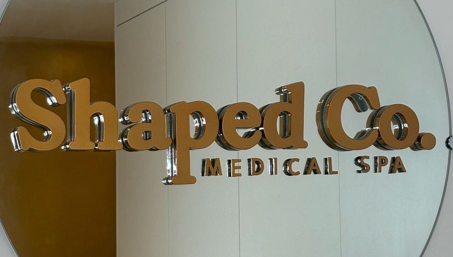 Reflective sign of Shaped Co. Medical Spa at Westhoughton, England, GB, on a sleek interior wall.