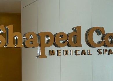 Reflective sign of Shaped Co. Medical Spa at Westhoughton, England, GB, on a sleek interior wall.