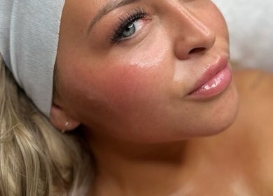 Relaxed woman enjoying facial at Shaped Co., Westhoughton, England, GB. Skin appears refreshed and rejuvenated.