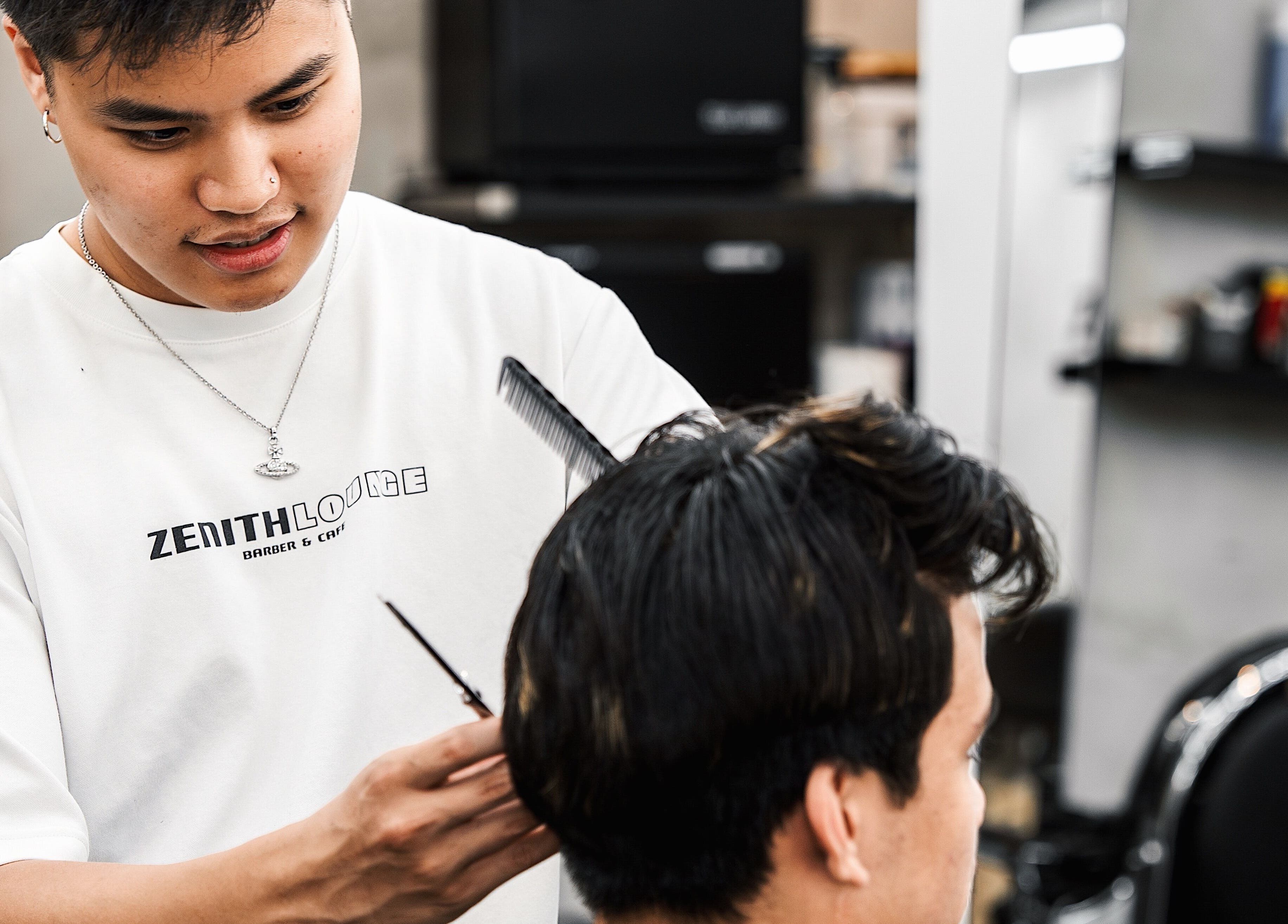 Barber giving a haircut at Zenith Lounge Barber & Cafe Kelvin Grove, Kelvin Grove, Queensland, AU.