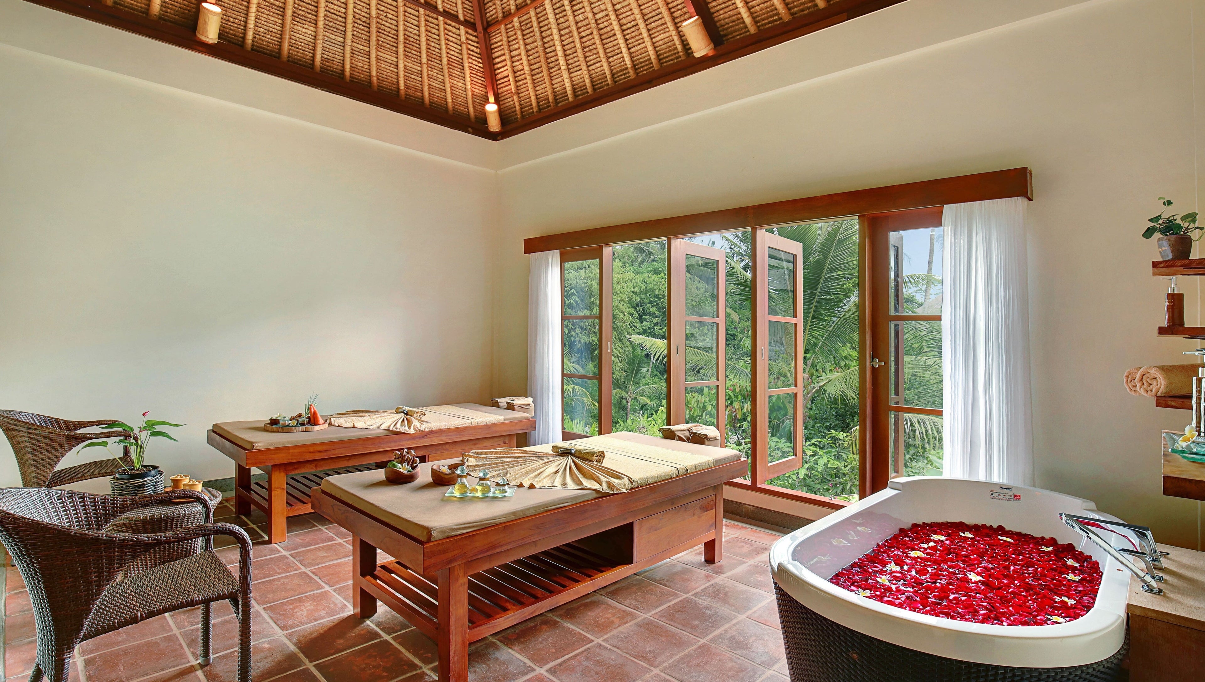 Relaxing spa room at Mahamaya Spa at Ubud Nyuh Bali Resort, Bali, Bali, ID, featuring massage tables and a petal bath.