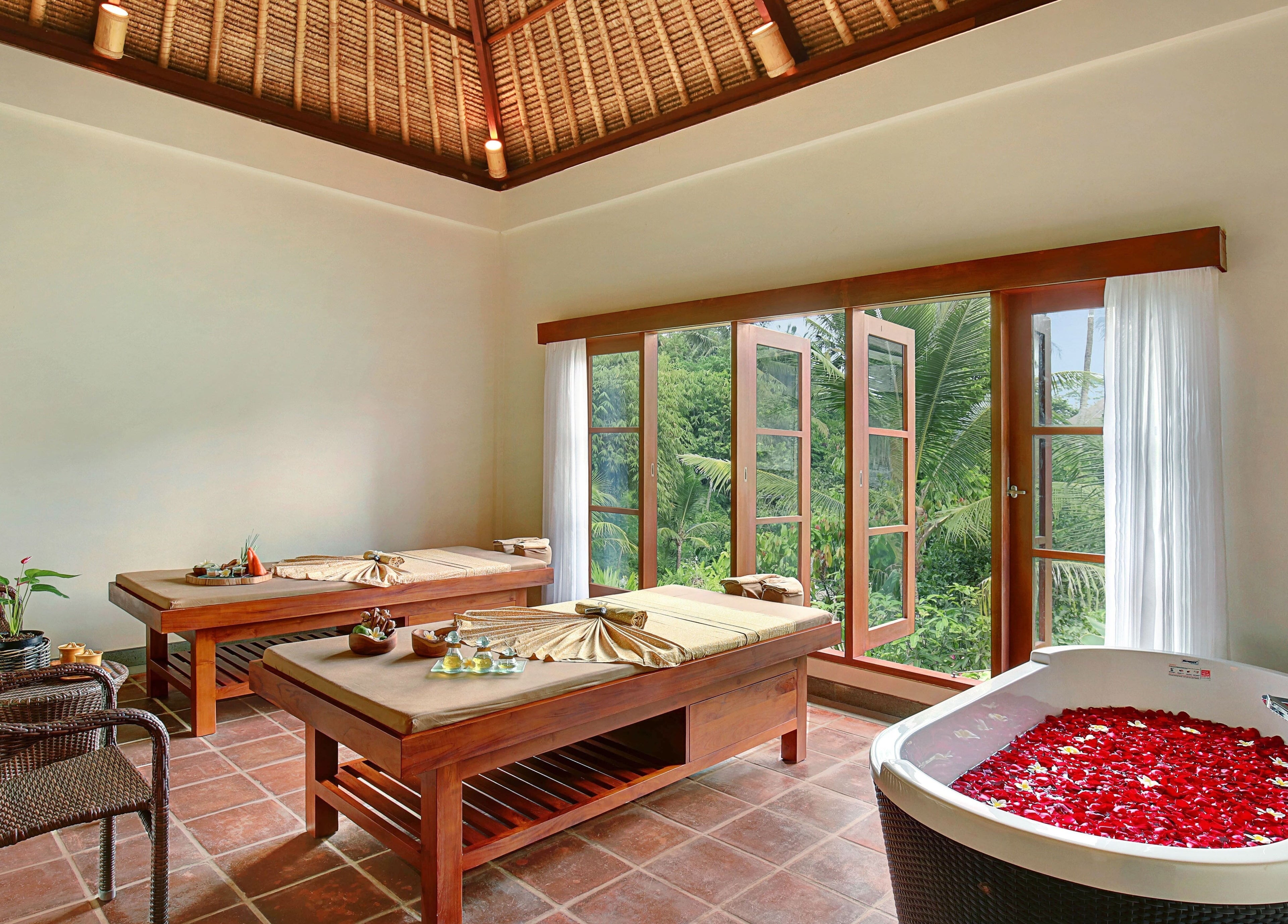 Relaxing spa room at Mahamaya Spa at Ubud Nyuh Bali Resort, Bali, Bali, ID, featuring massage tables and a petal bath.