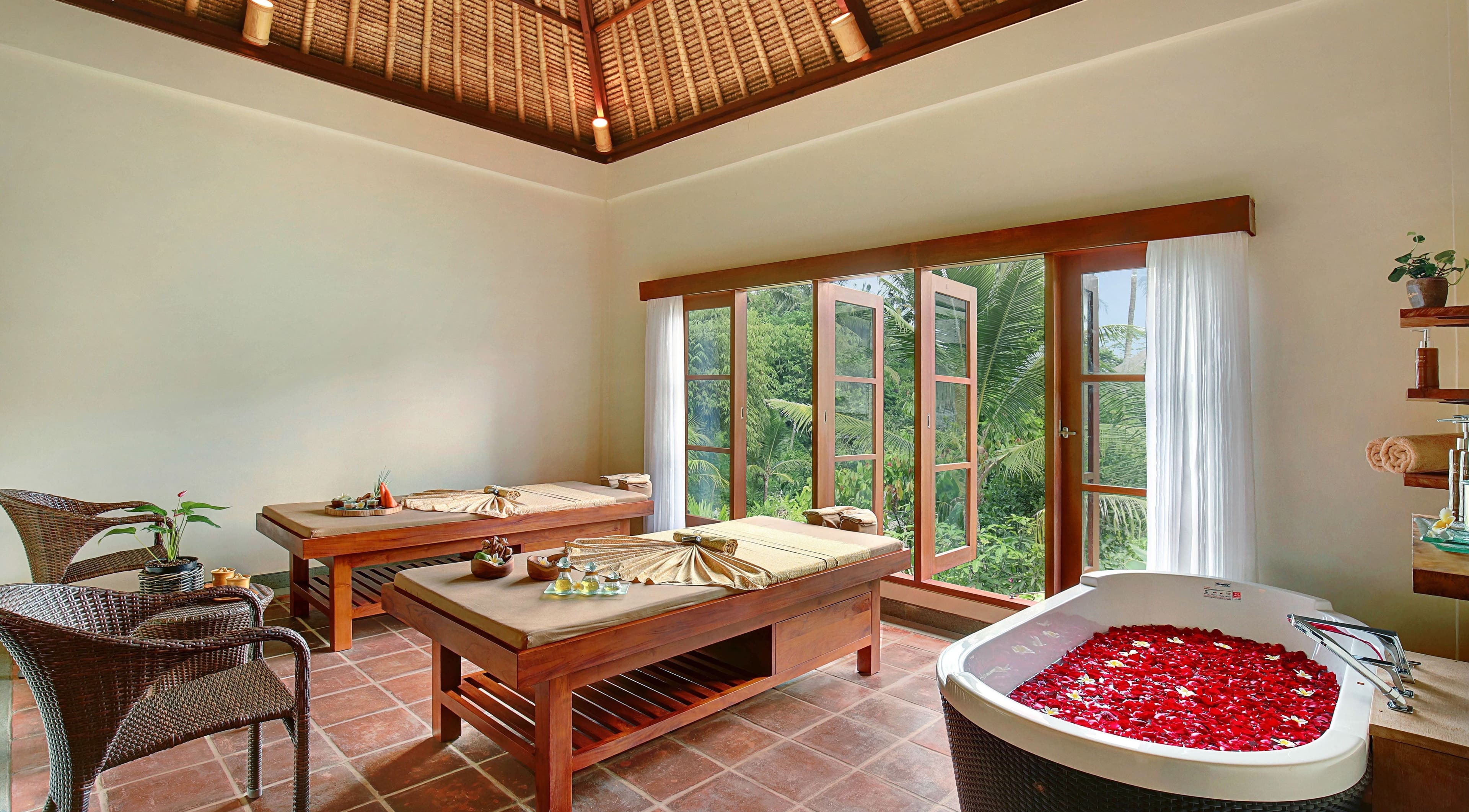 Relaxing spa room at Mahamaya Spa at Ubud Nyuh Bali Resort, Bali, Bali, ID, featuring massage tables and a petal bath.