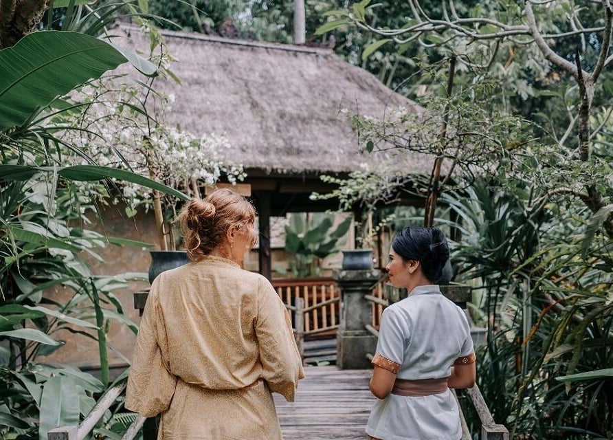 Visitors walking on the tranquil pathway at Mahamaya Spa at Ubud Nyuh Bali Resort, Bali, Bali, ID.