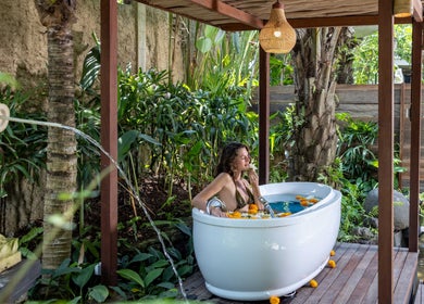 Outdoor bath at Mahamaya Spa at Ubud Nyuh Bali Resort in Bali, Bali, ID surrounded by lush greenery.