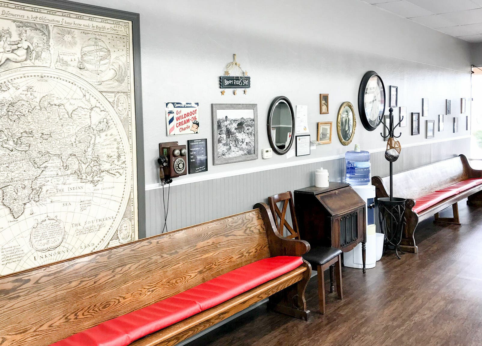 Retro seating area at CDO Barbershop in Tucson, Arizona, US, featuring classic decor and vintage maps.