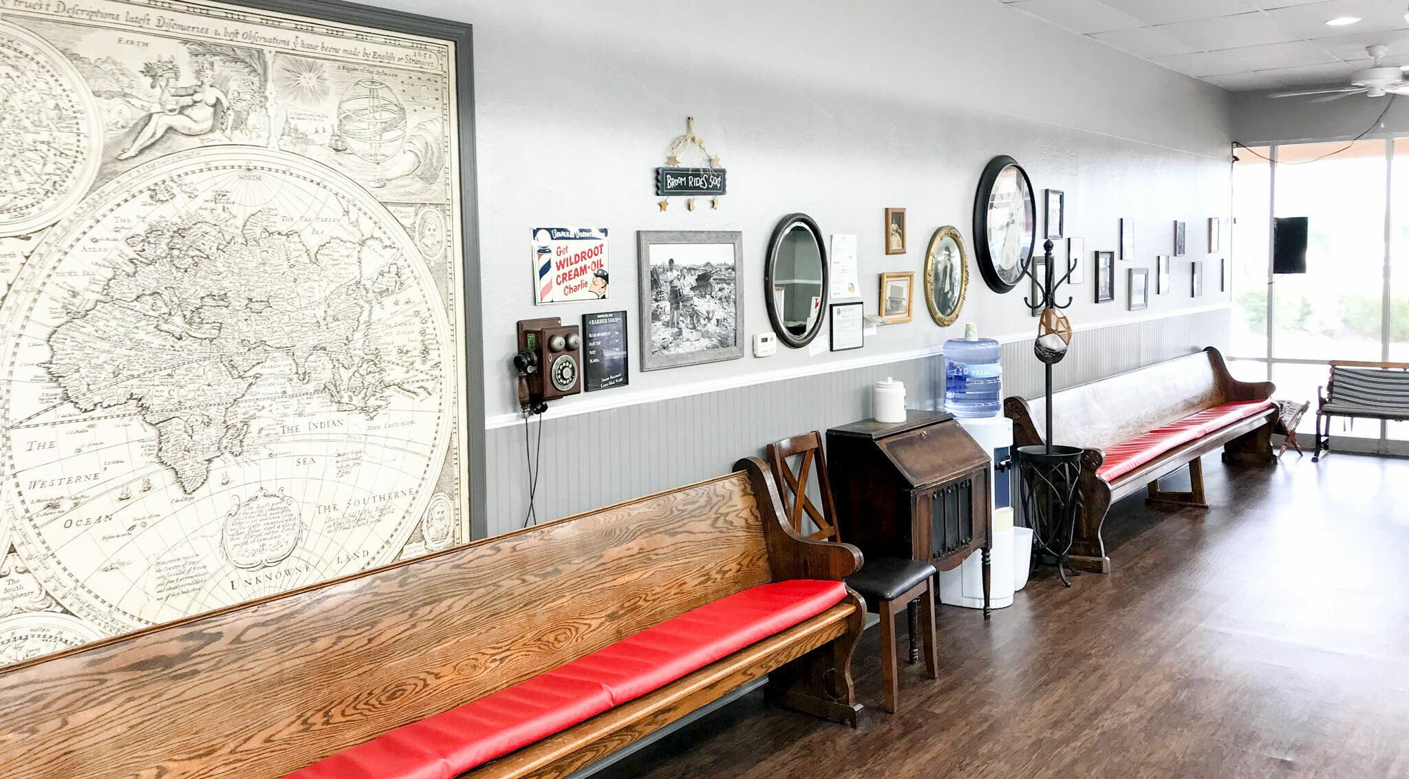 Retro seating area at CDO Barbershop in Tucson, Arizona, US, featuring classic decor and vintage maps.