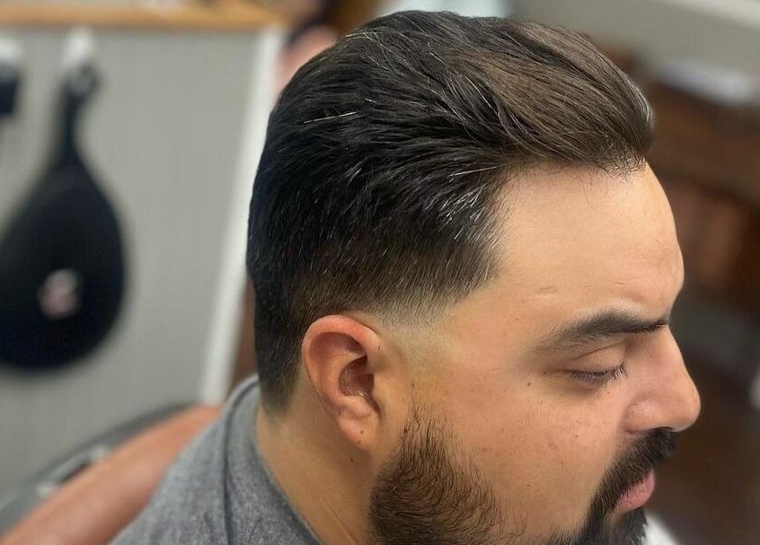 Man with sleek fade haircut at CDO Barbershop, Tucson, Arizona, US.