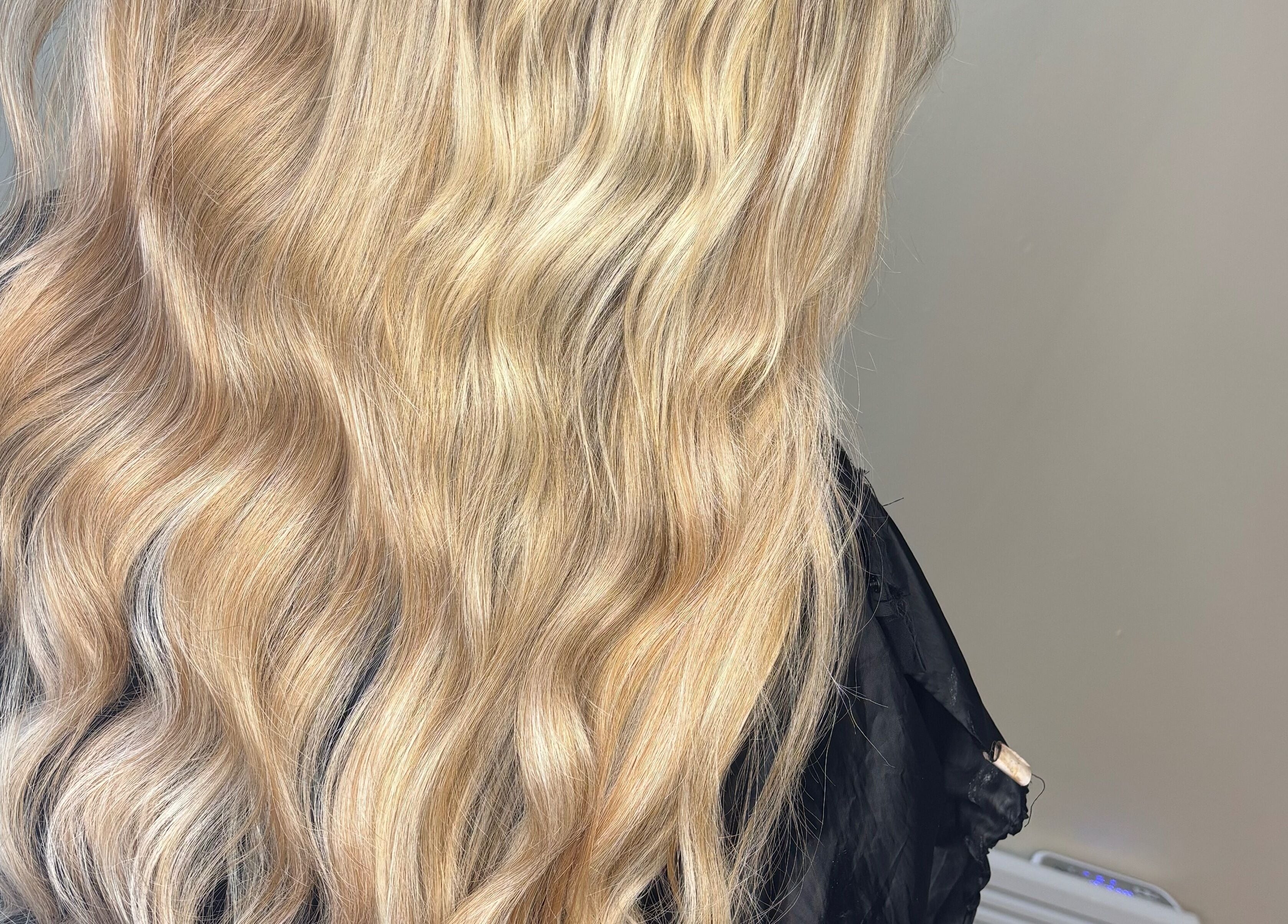Close-up of wavy blonde hair styled at Sweetie Hairdressing, Blythe Bridge, England, GB.