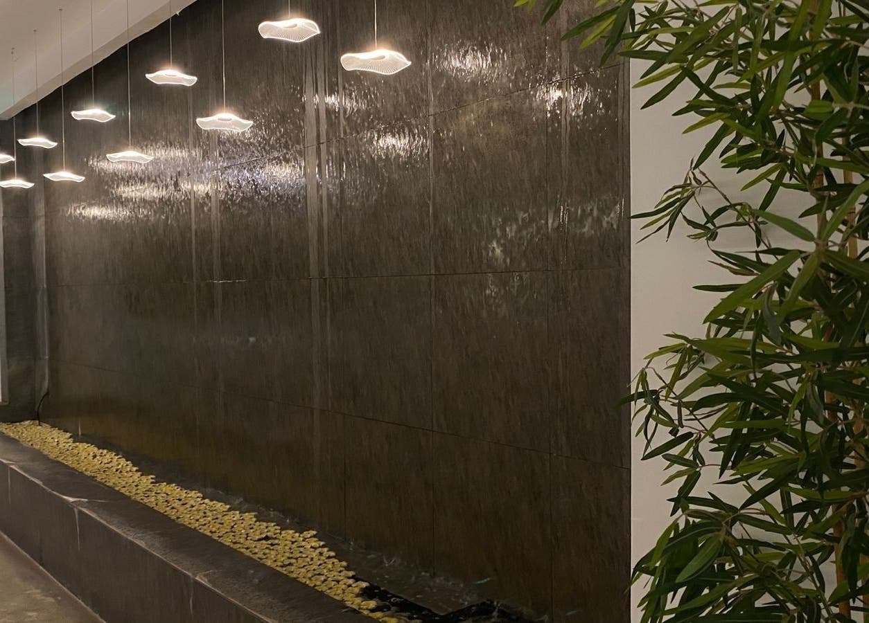 جدار مائي مضاء في سبا نيلا - الورود، الرياض، منطقة الرياض، السعودية يعكس أجواء هادئة.