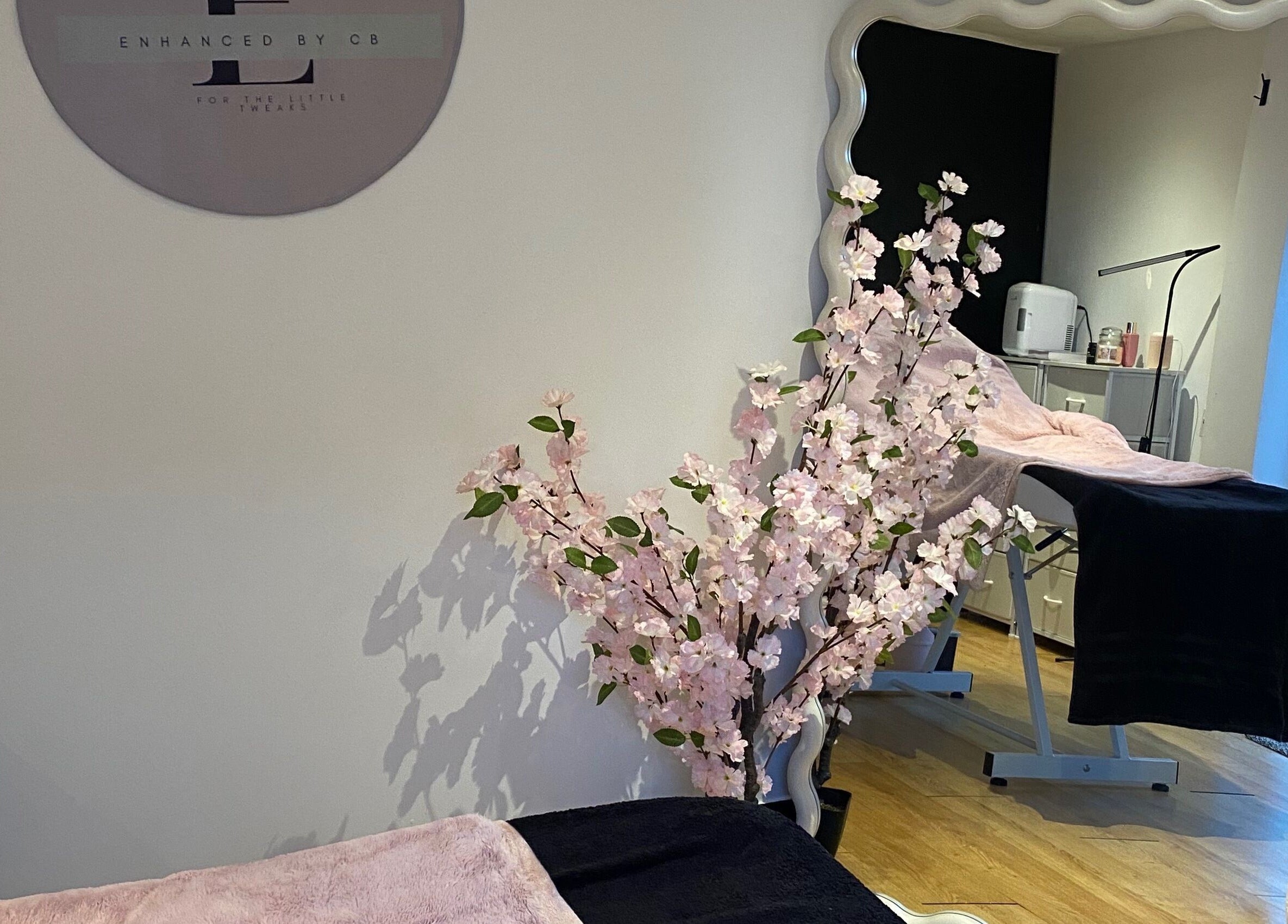 Calming treatment room at Enhanced.By CB, Worcester, England with cherry blossom decor and plush treatment bed.