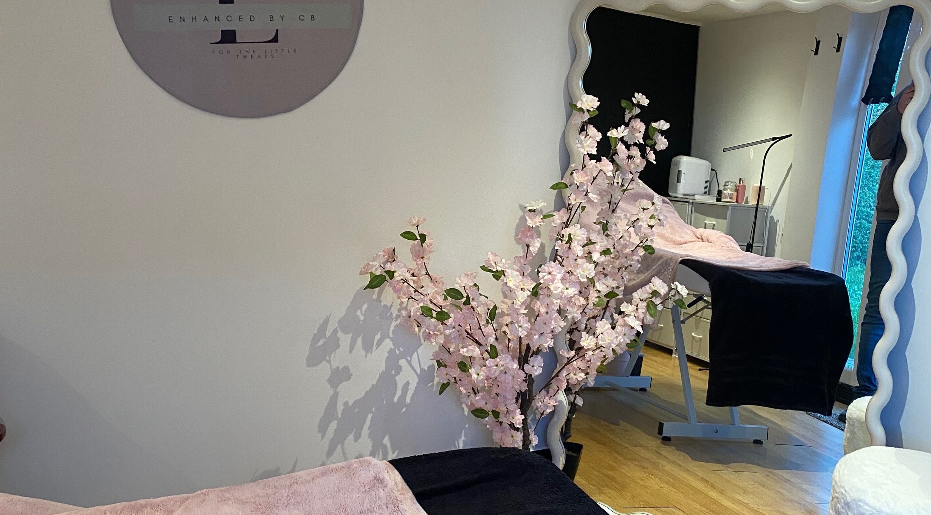 Calming treatment room at Enhanced.By CB, Worcester, England with cherry blossom decor and plush treatment bed.