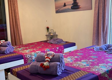 Sala massaggi serena presso Ascona Siam Massage Spa, Ascona, Ticino, CH, con tavoli e asciugamani ordinati.