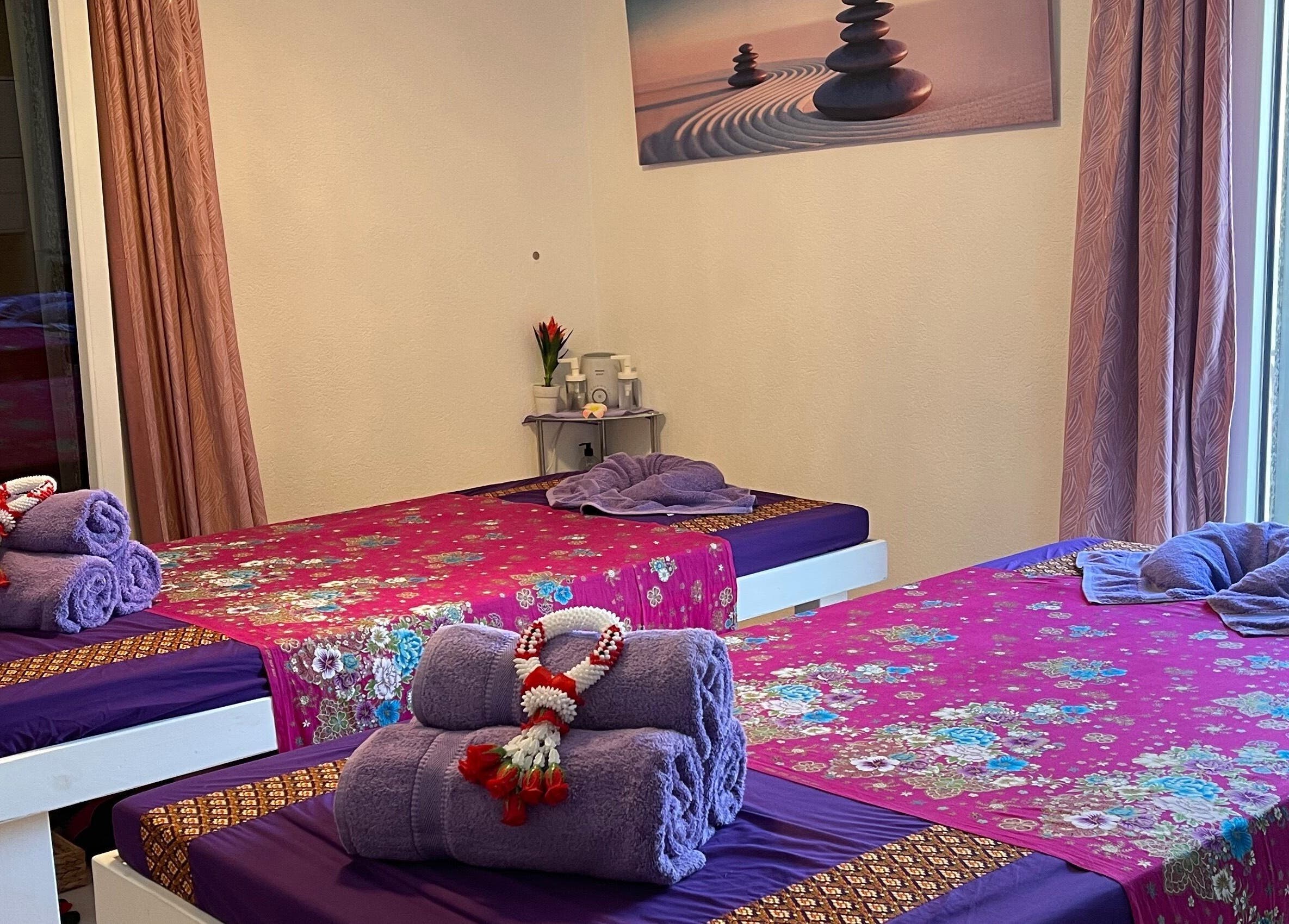 Sala massaggi accogliente all'Ascona Siam Massage Spa, a Ascona, Ticino, CH, con letti decorati.